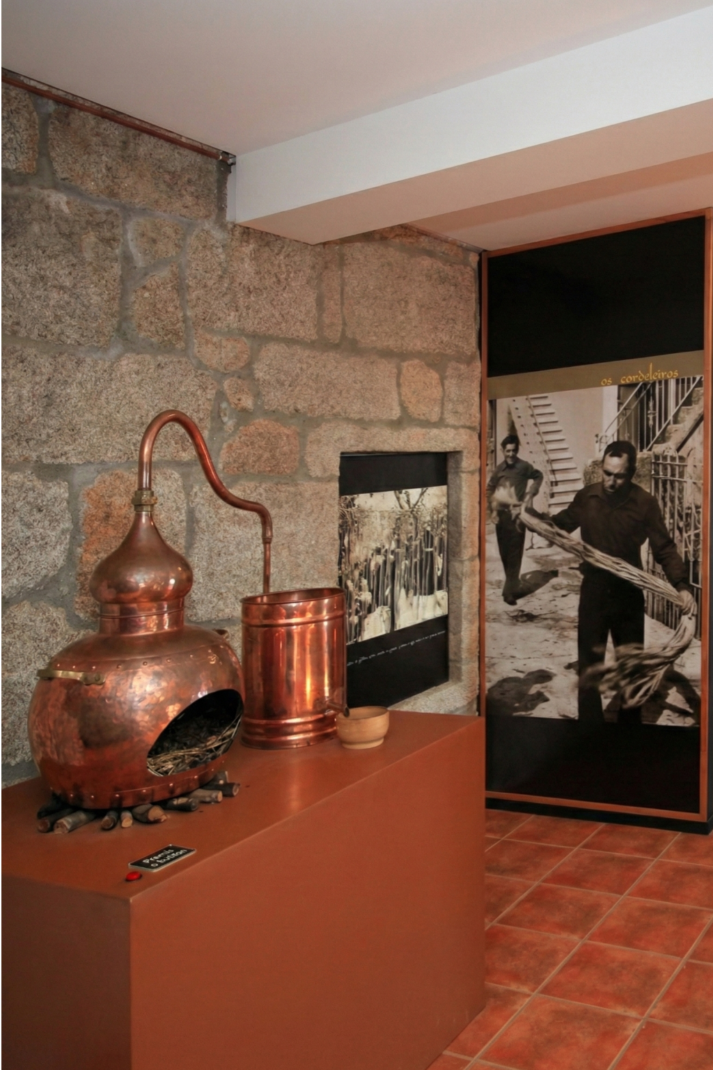 Interior de un museo etnográfico en la Ribeira Sacra mostrando un antiguo alambique de cobre.