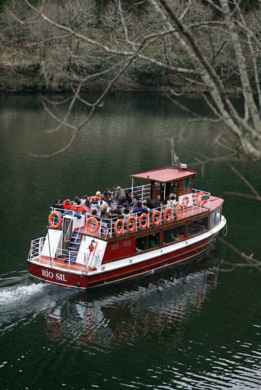 Catamarán navegando entre las paredes verticales del Cañón del Sil en la Ribeira Sacra.