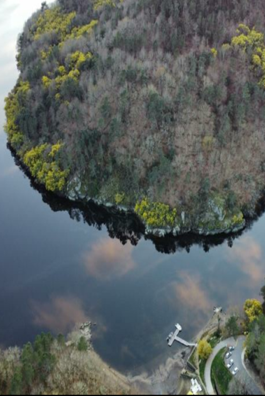 El río Miño y el embarcadero de Maiorga rodeado de bosques de otoño.