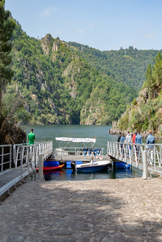 Grupo de personas subiendo a un barco en el embarcadero Os Chancís.