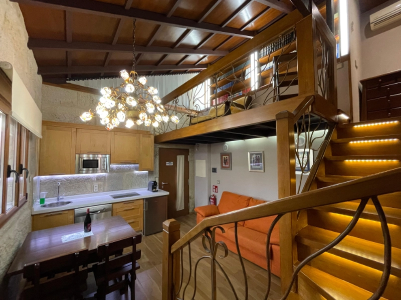 Arquitectura tipo loft con altillo de madera y salón acogedor en el Apartamento Chancís en la Ribeira Sacra.