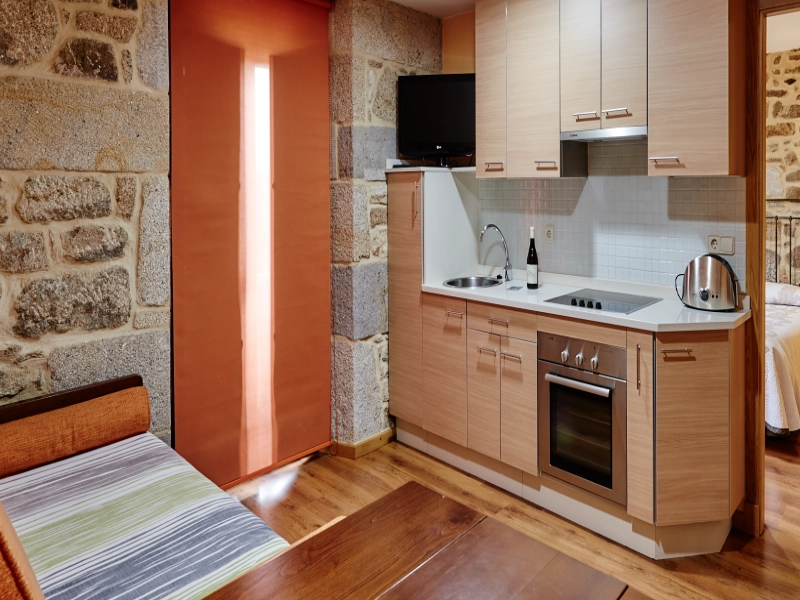 Cálida estancia de piedra y madera con cocina equipada en el Apartamento Boqueiriño en la Ribeira Sacra.