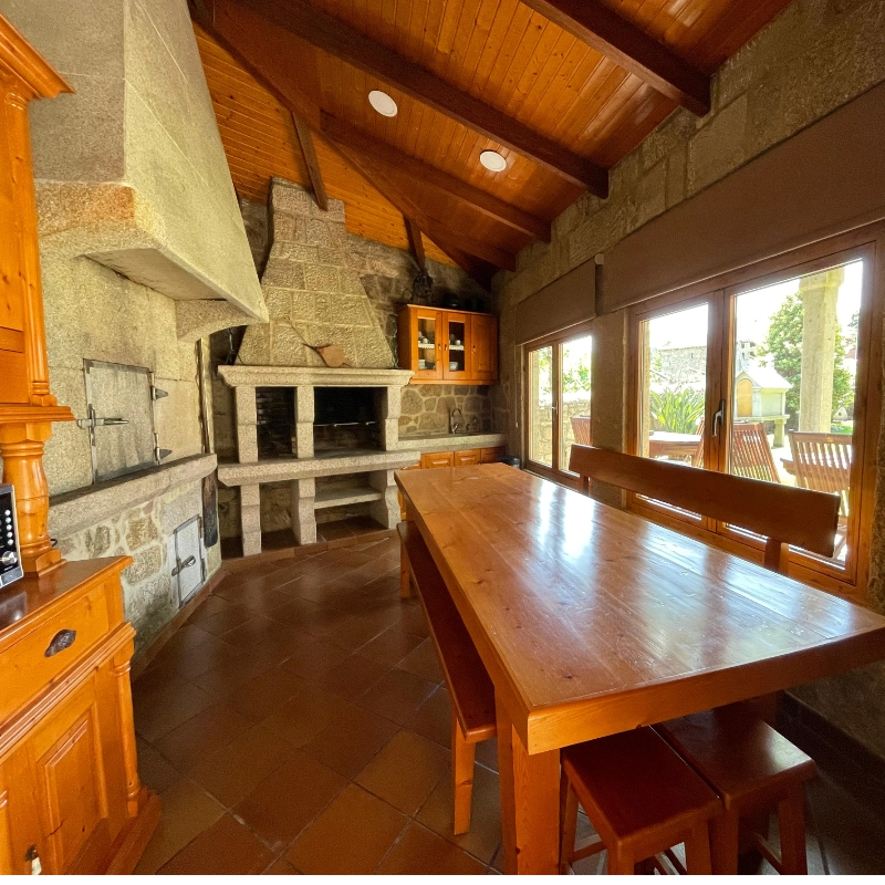 Asador comunitario con horno de leña y barbacoa interior, espacio adaptado en nuestra casa rural en la Ribeira Sacra.