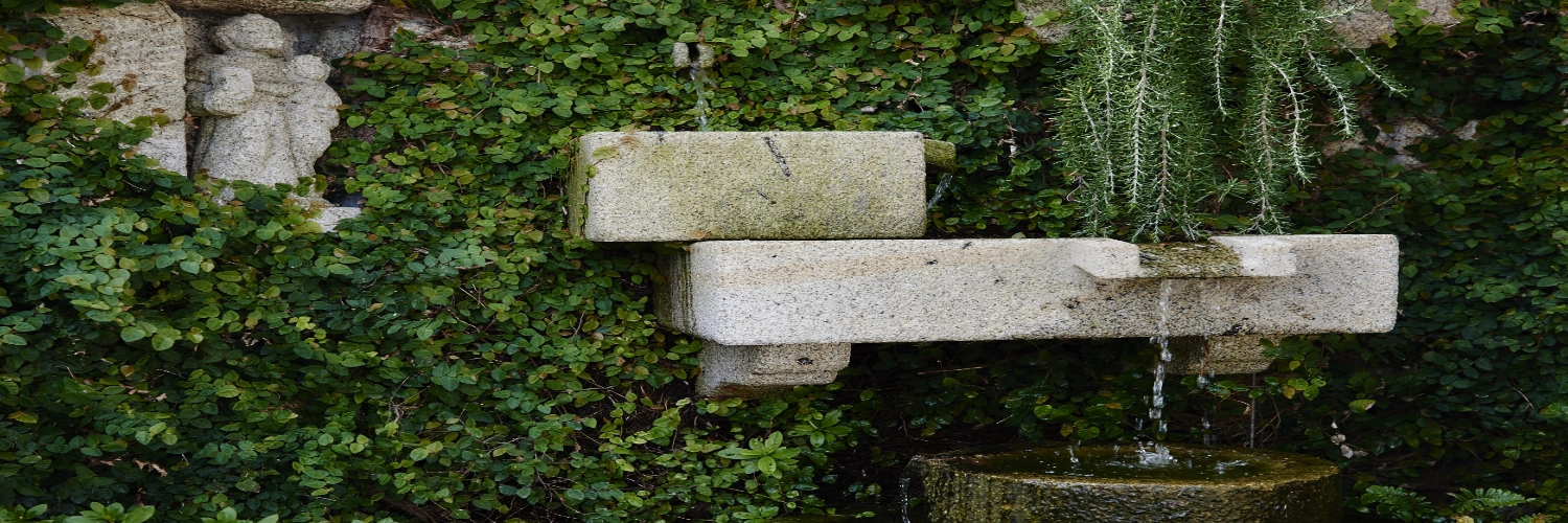 Fuente de agua artesanal en el jardín de nuestro alojamiento en Sober, Galicia.