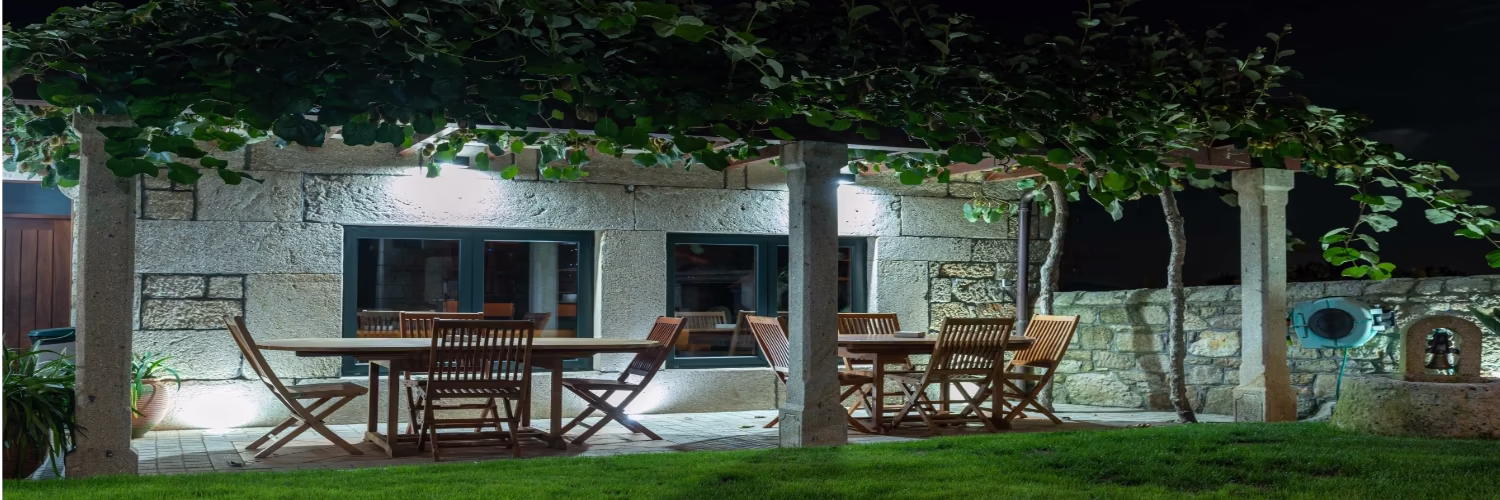 Comedor exterior bajo una parra de kiwis, ideal para tu escapada en la Ribeira Sacra.