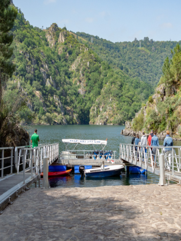 Grupo de personas subiendo a un barco en el embarcadero Os Chancís.